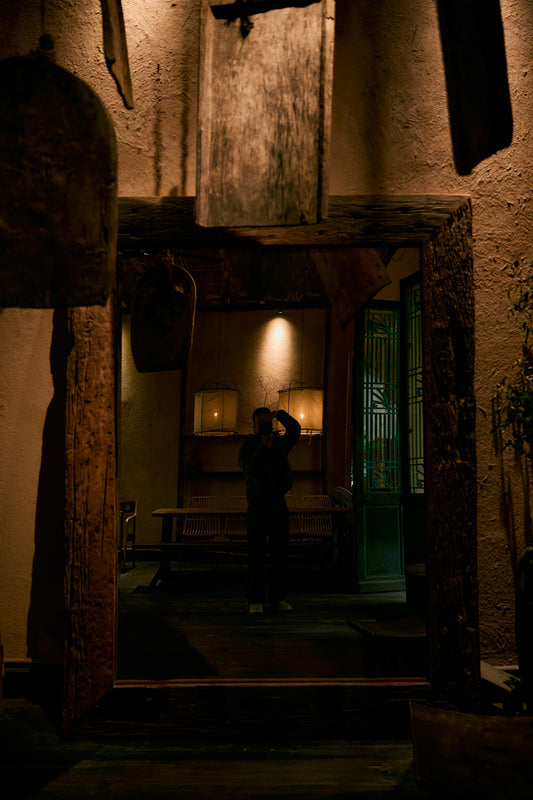 A person stands in a dimly lit room with lamps.