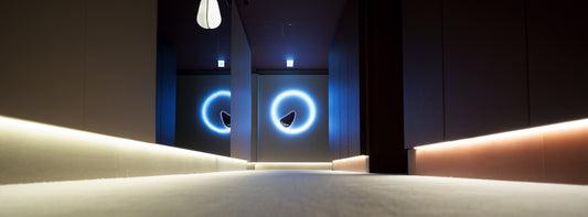 Modern hallway with blue neon circles and strip lighting.